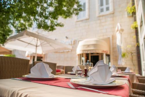 a table with plates and napkins on top of it at Hotel Biokovo in Makarska