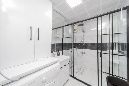 uma casa de banho branca com um chuveiro e um WC. em Fully Furnished Stylish Apartment in Antalya em Antalya