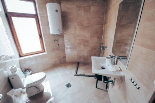 a bathroom with a white sink and a toilet at Nestor Apartments in Bitola