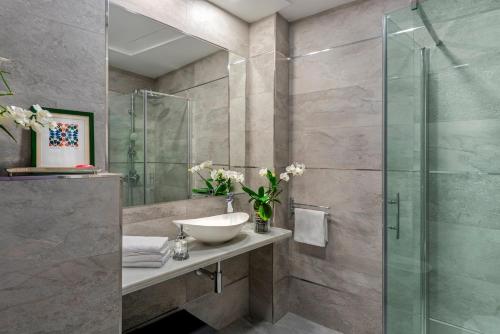a bathroom with a sink and a glass shower at Genteel Home Sagrado Corazón in Granada