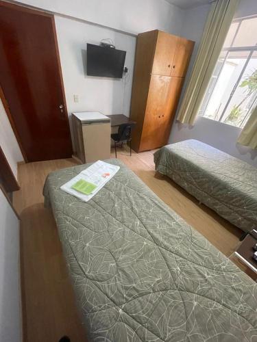 a hotel room with two beds and a television at Hara Palace Hotel in Curitiba
