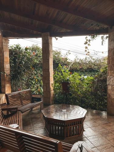 a patio with two wooden benches and a table at Finca Paraiso Mountain Retreat near San Jose Airport in Birrí