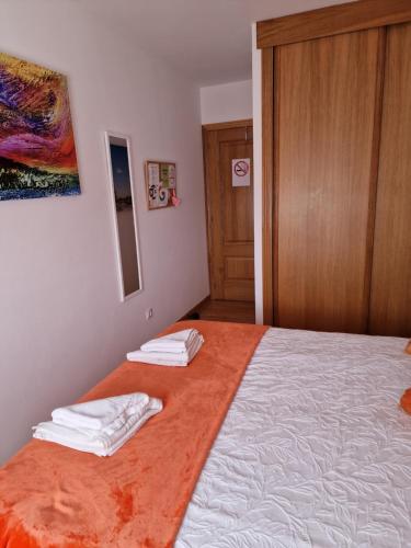 a bedroom with a bed with two towels on it at Pension Myriam O PEDROUZO in O Pedrouzo