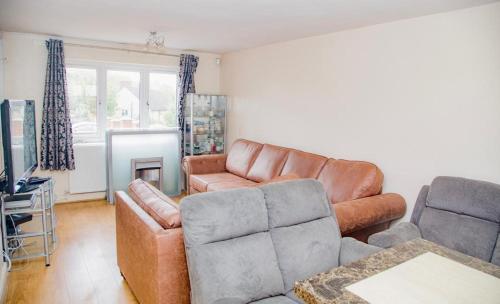 a living room with a leather couch and a chair at White House in Netherton