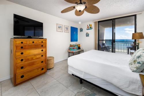 een slaapkamer met een bed, een televisie en een balkon bij Nautilus 1503 - Gulf Front 2 Bedroom 5th Floor in Fort Walton Beach