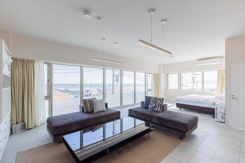 a bedroom with a bed and a couch and windows at MARSOL C,S,Beach hotel - Vacation STAY 50047v in Chigasaki