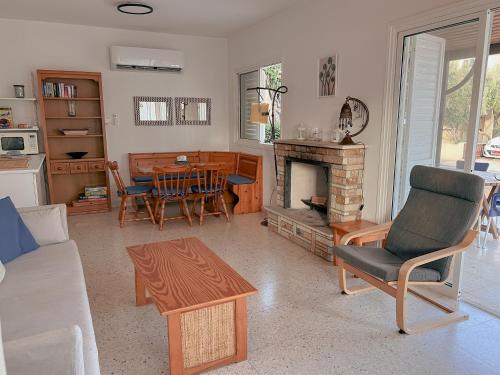 a living room with a fireplace and a table at Leo Boutique Beachfront in Ayia Napa