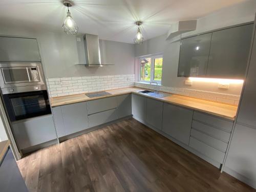a kitchen with white cabinets and a wooden counter top at 10 Tarleton Avenue, Woodhall Spa in Woodhall Spa