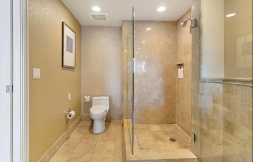a bathroom with a toilet and a glass shower at Singer Island Beach resort and Spa, Located at the Palm Beach Marriott in Riviera Beach