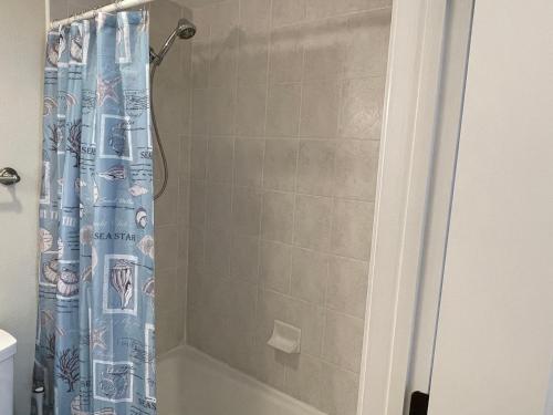 a shower with a blue shower curtain in a bathroom at Caribbean Resort 501A - Link To The Beach in Navarre
