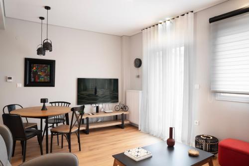 a living room with a table and a dining room at City Base Apartment in Thessaloniki
