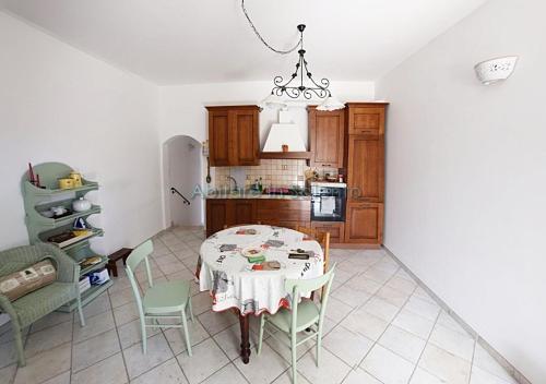 una cucina e una sala da pranzo con tavolo e sedie di Villetta con terrazzo antistante a Marina di Leuca