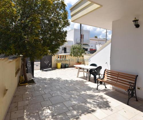 patio con panca in legno e tavolo di Villetta con terrazzo antistante a Marina di Leuca