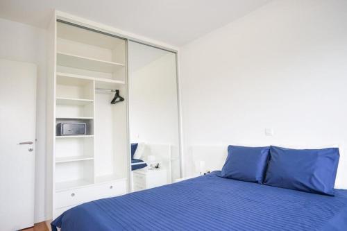ein Schlafzimmer mit einem blauen Bett und einem großen Spiegel in der Unterkunft Apartment Zara White in Zadar