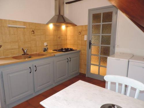 uma cozinha com um lavatório e uma bancada em Charmante maison de campagne em Chasteaux