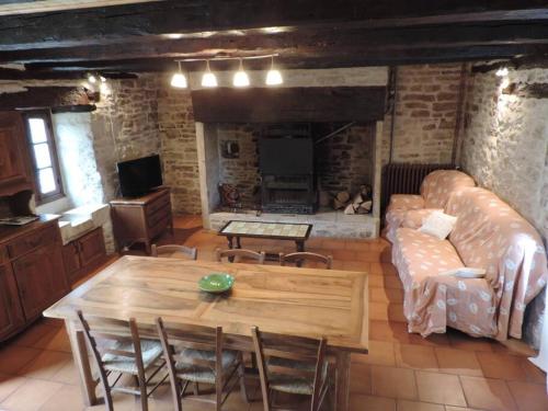 uma sala de estar com um sofá e uma mesa em Charmante maison de campagne em Chasteaux