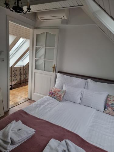 una camera da letto con un grande letto bianco e una finestra di DONATICOEUR Bellevue a Budapest