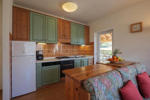 a kitchen with green cabinets and a white refrigerator at Casa Bellavista 1 in Colico