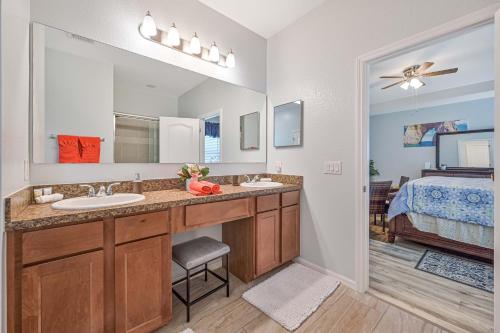 a bathroom with two sinks and a large mirror at CHEERFUL VILLA 4 BEDROOM AND A HOT TUB in Cape Coral