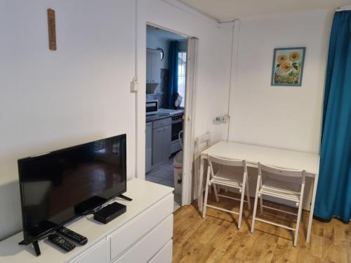 a living room with a television and a dining room table at Nébel Vendégház in Komárom