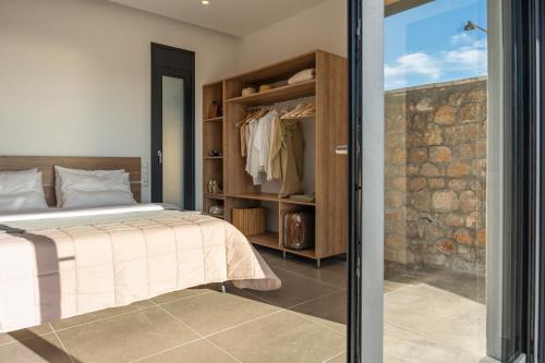 a bedroom with a bed and a sliding glass door at Casatino Villas in Kalianeika
