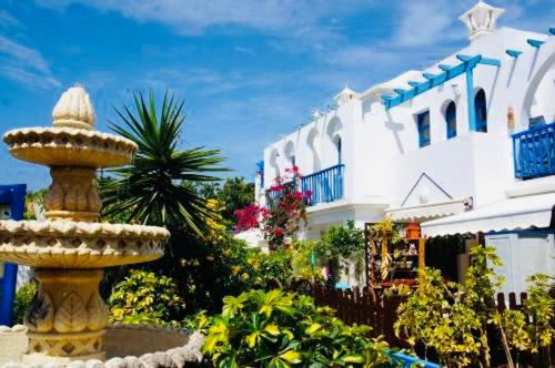 a fountain in a garden in front of a building at Maspalomas Casa Oceano in Maspalomas