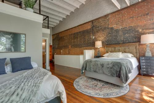 a bedroom with two beds and a brick wall at Kentucky Bourbon Loft about Downtown Louisville in Louisville