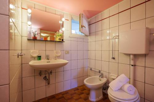 a bathroom with a sink and a toilet and a mirror at Casa Bellavista 1 in Colico