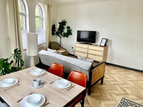 a living room with a couch and a table with chairs at The Dance School - 1 and 2 Bedroom Apartments in the Heart of Chesterfield in Chesterfield