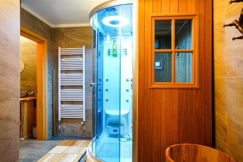 a glass shower in a room with a wooden wall at Luxury Love Chalet in Mrkopalj