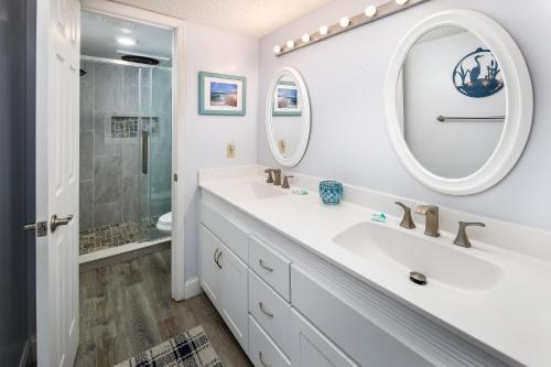 Baño blanco con lavabo y espejo en Nautilus 1601 - Gulf Front 2 Bedroom - 6th Floor - Huge Wraparound Balcony, en Fort Walton Beach