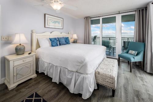 1 dormitorio con 1 cama blanca y 1 silla azul en Nautilus 1601 - Gulf Front 2 Bedroom - 6th Floor - Huge Wraparound Balcony, en Fort Walton Beach