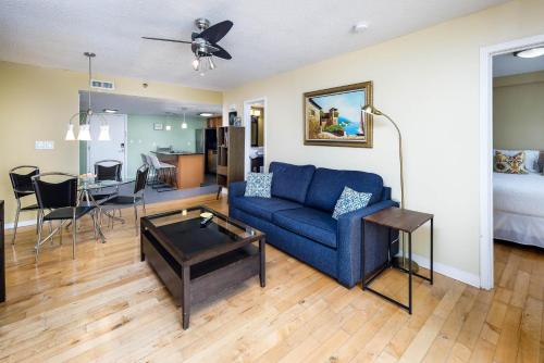 een woonkamer met een blauwe bank en een tafel bij Nautilus 1505 - Gulf Front 1 Bedroom - 5th Floor in Fort Walton Beach