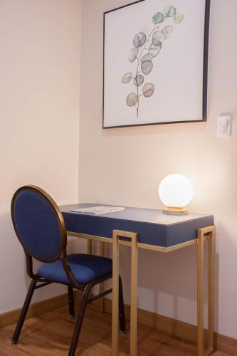 a blue desk with a chair and a lamp at Bisinii Boutique Hotel in Ciudad del Este