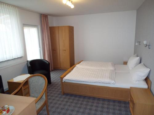 1 dormitorio con 1 cama, 1 mesa y 1 silla en Hotel garni Zum Reinhardswald, en Gewissenruh