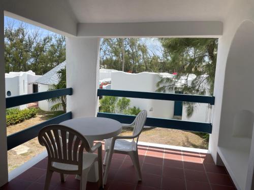 a balcony with a table and chairs and a window at OceanBlue Resort in Christ Church