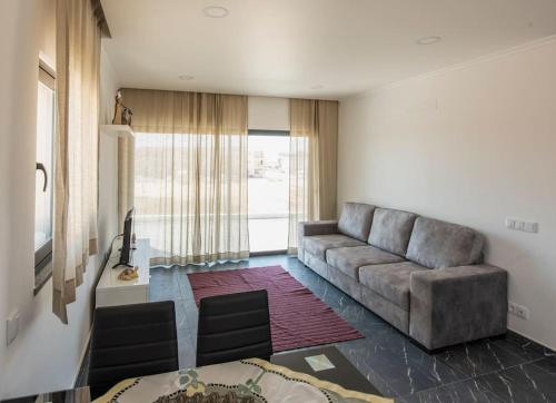 a living room with a couch and a table at Sunset House in Vila do Bispo