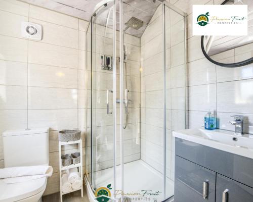 a bathroom with a shower and a toilet and a sink at 3 Bedroom Coventry House By Passionfruitproperties with Free Wi-fi, Large Garden and Driveway - 52NRC in Coventry