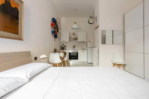 - une chambre blanche avec un grand lit et une cuisine dans l'établissement Appartamento il Mugnaio, à Bologne