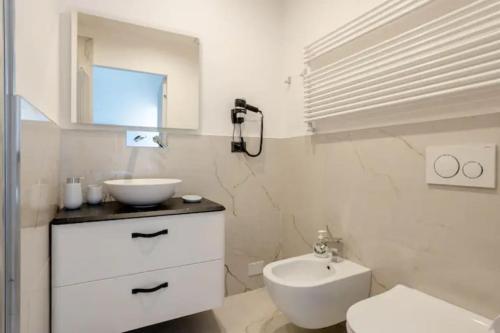 La salle de bains blanche est pourvue d'un lavabo et de toilettes. dans l'établissement Appartamento il Mugnaio, à Bologne