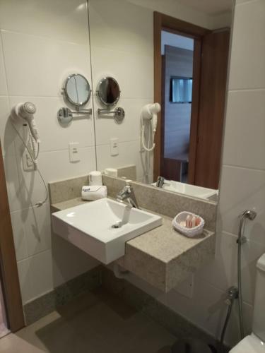 La salle de bains est pourvue d'un lavabo et d'un miroir. dans l'établissement Condomínio Vista Azul Hotel, à Pedra Azul