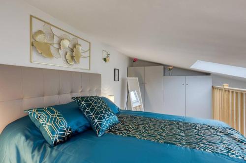 um quarto com uma cama azul e 2 almofadas em L'élégante maisonnette - T2 - paris - Orly - RER C em Vitry-sur-Seine