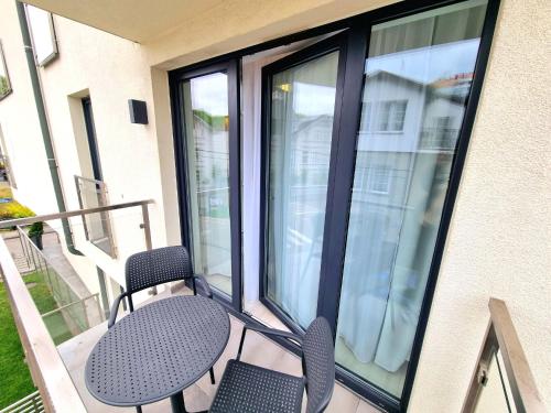a patio with two chairs and a table on a balcony at Baltic Soul Villa in Międzyzdroje