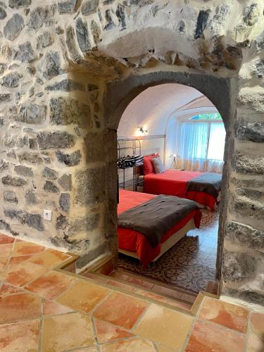 - une chambre avec 2 lits dans un mur en pierre dans l'établissement Mas des TRAVES Anduze avec piscine, à La Barriére
