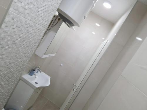 La salle de bains blanche est pourvue de toilettes et d'un lavabo. dans l'établissement Apartman Platan, à Trebinje