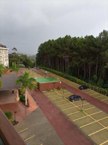 佩德拉阿祖爾的住宿－Condomínio Vista Azul Hotel，享有带网球场的停车场的顶部景致