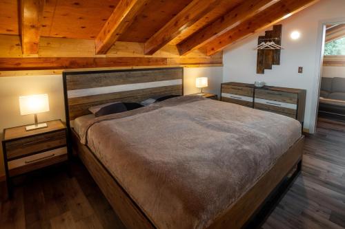 a bedroom with a large bed and two lamps at Red Cariboo Resort in Anahim Lake