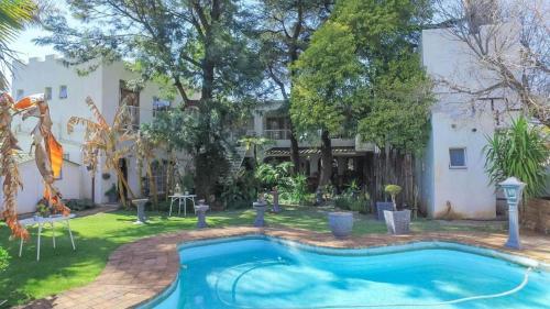 a swimming pool in the yard of a house at Just Tiffany Guest House & Conference Facility in Potchefstroom
