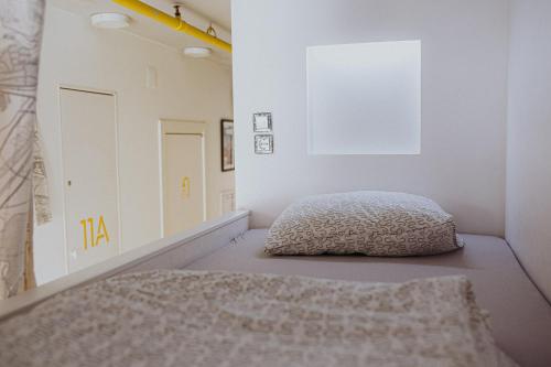 a bedroom with a bed and a white wall at Private Rooms at Hostel63 in Zagreb