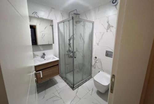 ein Bad mit einer Dusche, einem WC und einem Waschbecken in der Unterkunft Enoya Suites Ilıca in Cesme